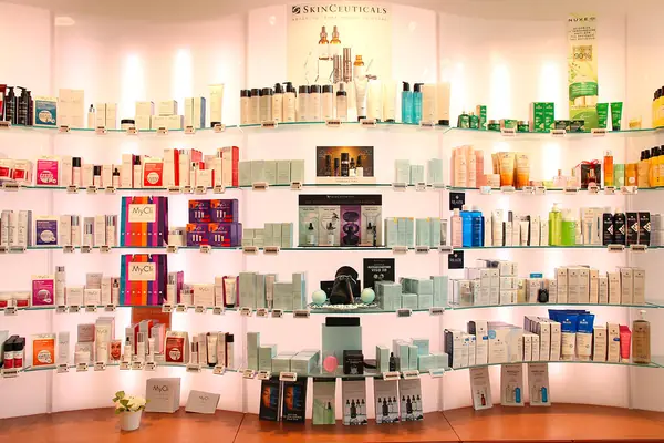 Espositore curvo di dermocosmesi con prodotti SkinCeuticals e Nuxe